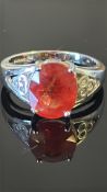18k white gold ring centring an oval 3.70 ct padparadscha sapphire, claw-set between pierced trefoil