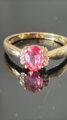 18K yellow gold ring centring an oval Ceylon padparadscha sapphire, approx 0.85 ct, flanked by
