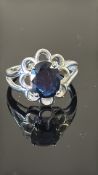 18K white gold ring centring a 2.17 ct oval royal blue sapphire within openwork petal bezel, split
