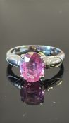 18k white gold ring claw-set with an oval hot pink sapphire (approx 10 × 8 mm, 2.50 ct), flanked