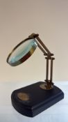 Brass magnifying glass on wooden base