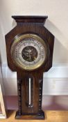 Oak cased aneroid barometer with brass bezel and inset Celsius/Fahrenheit thermometer, silvered dial