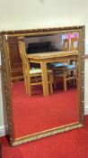 Ornate gilt and burgundy framed wall mirror