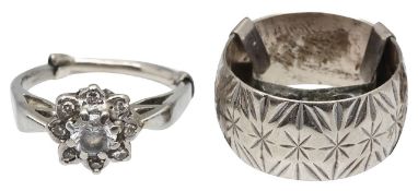 A 9ct white gold wide band with a diamond and white stone cluster