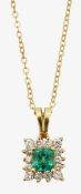 An emerald and diamond cluster pendant