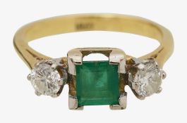 An emerald and diamond three stone ring