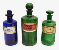 A group of three glass poison bottles and stoppers
