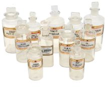 A collection of clear glass apothecary bottles and stoppers