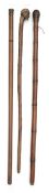 A group of three carved wood walking sticks
