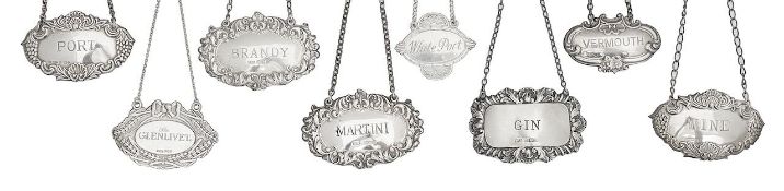 A group of eight Elizabeth II silver decanter labels