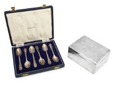A George V silver cigarette box and cased set of teaspoons