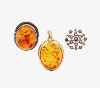 An Edwardian amethyst brooch pendant, an amber pendant and ring