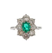 An emerald and diamond cluster ring