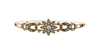 An Edwardian hinged bangle seed pearl flower cluster
