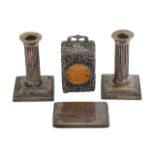 A pair of George V silver candlesticks, a silver carriage clock and a silver card case
