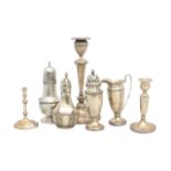 A collection of silver candlesticks, sifters and a cream jug