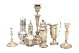 A collection of silver candlesticks, sifters and a cream jug