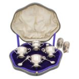 A cased George V silver cruet set, and two Victorian pepperettes