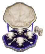 A cased George V silver cruet set, and two Victorian pepperettes