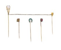 A diamond and ruby pin, diamond cross pin, horse shoe and one other