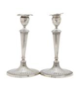 A pair of George III Adam style silver candlesticks