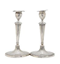 A pair of George III Adam style silver candlesticks