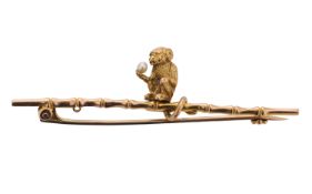 A 9ct gold novelty bar brooch, of a monkey holding a seed pearl