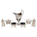 A George III silver cream jug, and a George V silver six piece cruet set