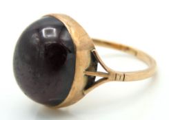 An antique 9ct rose gold ring set with cabochon cu