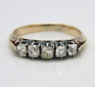 A yellow metal ring set with five diamonds, two are later replacements, one drawing colour (centre),