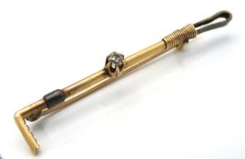 An antique 15ct gold riding crop brooch, 46mm wide