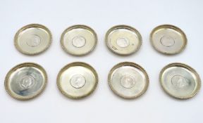 Eight silver dishes set with silver rupee's, coin