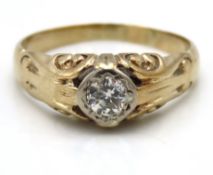 A yellow metal ring with carved decor set with app