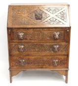 An oak writing bureau with lion head handles, 980m