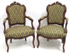 A pair of upholstered French carved walnut armchai