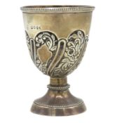 An 1887 silver egg cup with floral repoussé decor