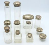 A collection of twelve glass dressing table jars &