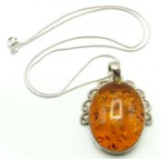An amber pendant with decorative silver mount & silver chain, 49mm drop, chain 410mm