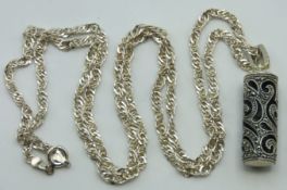 A silver chain with cylindrical pendant with fretw