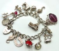 A silver charm bracelet with fourteen charms, 180m