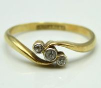 An 18ct gold antique three stone crossover ring set with platinum mounted diamonds of approx. 0.1ct,