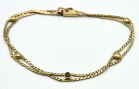 A 9ct gold double strand bracelet fitted with gree