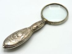 A sterling silver reading glass with repoussé deco