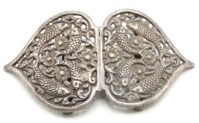 A Tibetan white metal buckle with carved decor of