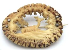 A Victorian carved antler horn brooch with recumbe
