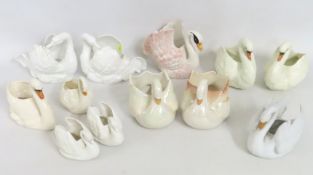 A collection of twelve pottery swans, largest 160m