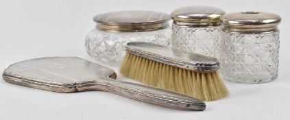 THREE SILVER LIDDED GLASS VANITY DRESSING JARS & MIRROR AND A BRUSH