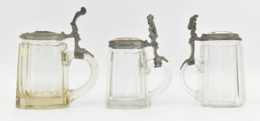 THREE EARLY 20TH CENTURY GERMAN CUT GLASS AND PEWTER LIDDED STEINS