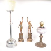 TWO 20TH CENTURY OIL LAMPS AND TWO SPELTER FIGURES OF TORCH BEARERS