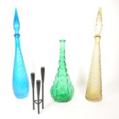 THREE MID CENTURY COLOURED GLASS GENIE BOTTLES WITH METAL CANDLESTICK HOLDER